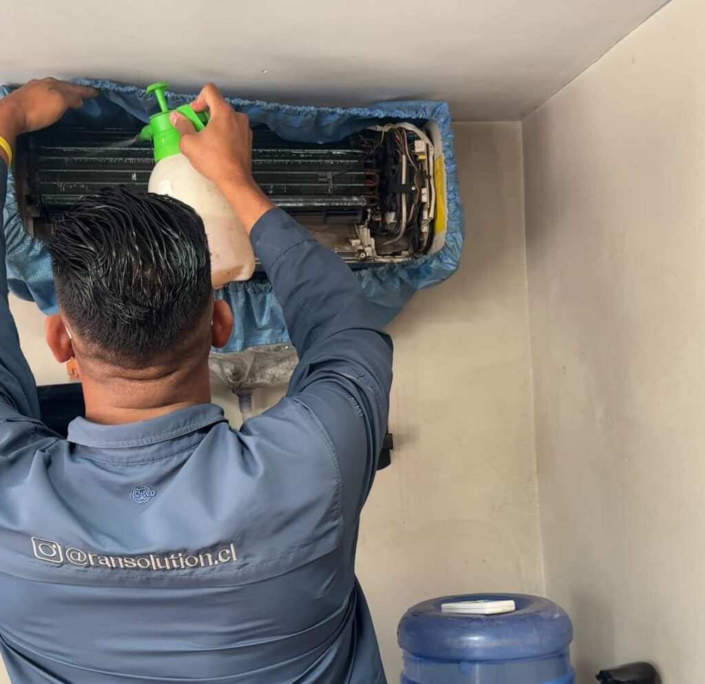 técnico revisando aire acondicionado en servicio de mantención en Santiago